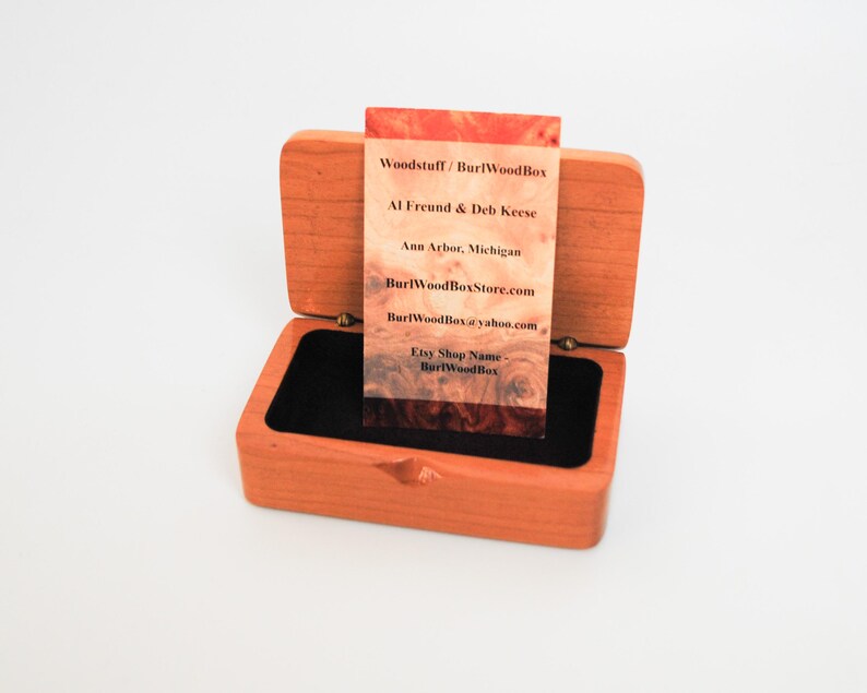 May include: A wooden box with a black velvet interior, open to reveal a business card with the text "Woodstuff/ Burl Wood Box", "Al Freund & Deb Keese", "Ann Arbor, Michigan", "BurlWoodBoxStore.com", "Burl WoodBox yahoo.com", "Etsy Shop Name", "BurlWood Box".