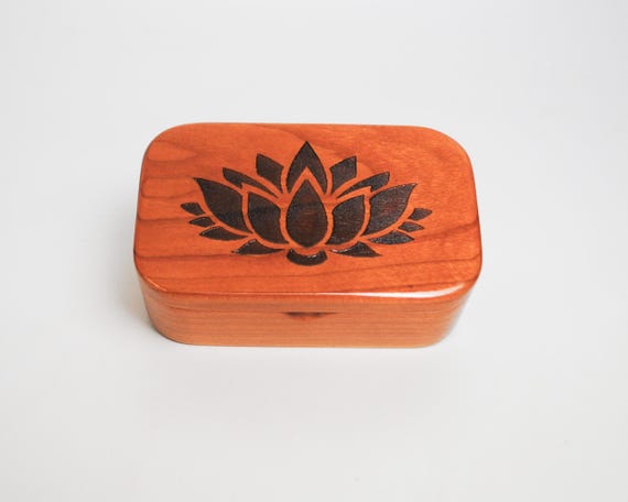 Hand-carved cherry burled wood trinket box with a lotus engraving — the natural grain makes every single one genuinely one-of-a-kind.