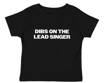Könnte beinhalten: Schwarzes Kinder-T-Shirt mit dem Aufdruck "DIBS ON THE LEAD SINGER" in weißen Großbuchstaben. Das T-Shirt ist einfarbig schwarz und hat kurze Ärmel.
