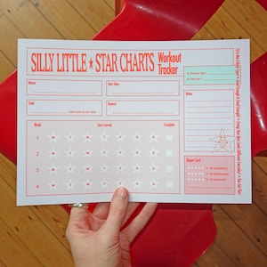 Könnte beinhalten: Ein Trainings-Tracker aus weißem Papier mit dem Titel Silly Little Star Charts in roter Schrift und Grafik. Er enthält Felder für Name, Startdatum, Ziel, Belohnung und ein vierwöchiges Raster mit Sternsymbolen zur Verfolgung des täglichen Fortschritts.