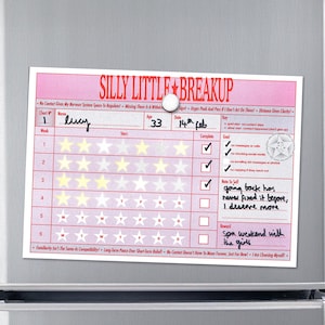 May include: A pink and white breakup chart magnet with the title "Silly Little Breakup." The chart includes sections for name, age, and date, with checkboxes and star ratings. Handwritten notes and a reward are also visible.