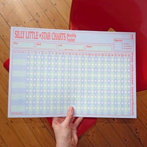 Könnte beinhalten: Ein rechteckiges monatliches Tracker-Diagramm mit dem Titel SILLY LITTLE STAR CHARTS in roter Schrift auf weißem Hintergrund. Es enthält Felder für Name, Monat, Ziel und Belohnung, einen Zeugnisbereich und ein Raster für 31 Tage mit weißen Sternen.