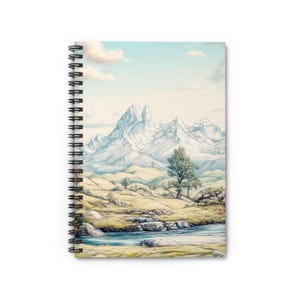 Pode incluir: Caderno espiral com uma ilustração de paisagem. A capa mostra uma cordilheira com picos cobertos de neve, um rio e árvores sob um céu azul com nuvens. A encadernação em espiral do caderno é preta.