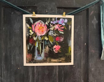 May include: An abstract floral painting featuring a bouquet of pink, red, and purple flowers in a clear vase. The artwork is mounted on a white background and held by gold clips against a dark background.