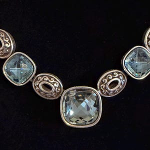 May include: A white ceramic mug with a black handle and the text "But First, Coffee" in a handwritten style. The mug is on a white surface.