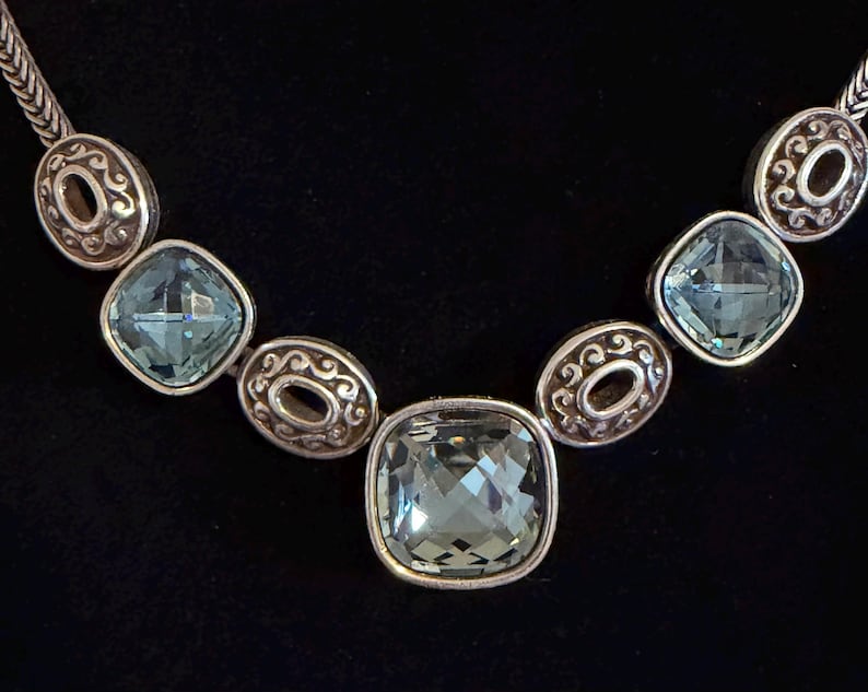 May include: A white ceramic mug with a black handle and the text "But First, Coffee" in a handwritten style. The mug is on a white surface.