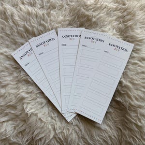 May include: Five white annotation key cards with the text "ANNOTATION KEY" in black and pink. Each card has a title line and several lined boxes. The cards are arranged on a fluffy, white surface.