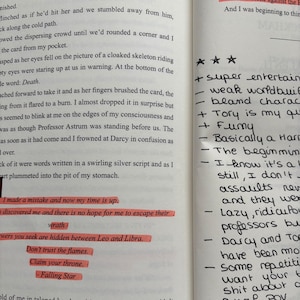 Puede incluir: P&aacute;ginas de un libro abierto con notas manuscritas y texto resaltado. La p&aacute;gina izquierda contiene texto narrativo, mientras que la p&aacute;gina derecha tiene vi&ntilde;etas y valoraciones con estrellas. El texto incluye frases como "Death" y "Falling Star."