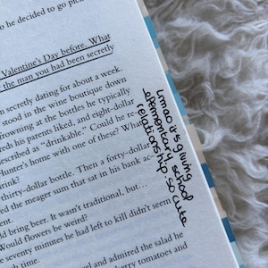 May include: Open book with printed text and handwritten notes. The text includes phrases like "Valentine's Day before" and "drinkable." Handwritten text says "Lmao it's giving elementary school relationship. so cute."