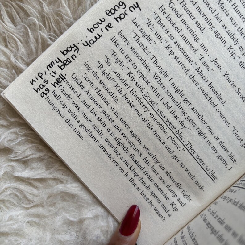 May include: An open book with handwritten notes in black ink. The text includes phrases like "Kip, my boy...has it been?" and "You're horny." The page also features printed text with highlighted sentences.