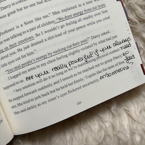 Puede incluir: P&aacute;gina de un libro abierto con texto impreso y notas manuscritas. El texto incluye frases como "Extraemos energ&iacute;a de nuestros anfitriones" y "Robas la energ&iacute;a de la gente". Las notas manuscritas dicen "&iquest;Eres realmente poderoso si siempre".