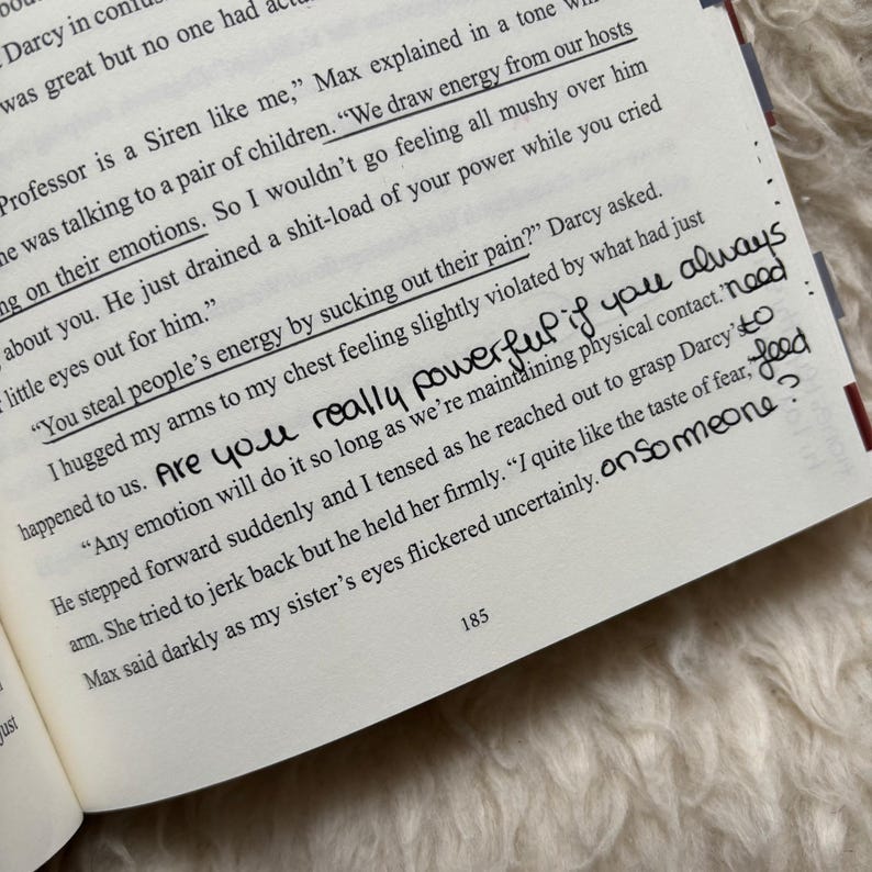 Puede incluir: P&aacute;gina de un libro abierto con texto impreso y notas manuscritas. El texto incluye frases como "Extraemos energ&iacute;a de nuestros anfitriones" y "Robas la energ&iacute;a de la gente". Las notas manuscritas dicen "&iquest;Eres realmente poderoso si siempre".