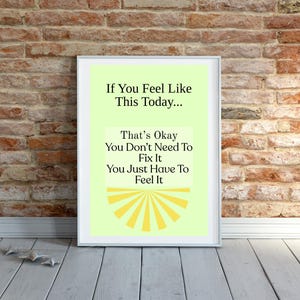 Könnte beinhalten: Ein gerahmter Druck mit hellgrünem Hintergrund und dem Text "If You Feel Like This Today... That's Okay You Don't Need To Fix It You Just Have To Feel It." Der Rahmen ist weiß, der Hintergrund eine Backsteinmauer.