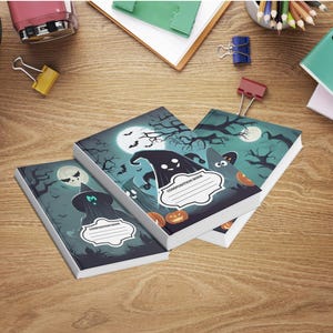 Puede incluir: Tres cuadernos de composición con temática de Halloween con ilustraciones de fantasmas, murciélagos y calabazas bajo la luna llena. Los cuadernos tienen una etiqueta blanca para el nombre del propietario. Sobre una superficie de madera.