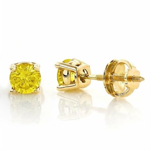 K&ouml;nnte beinhalten: Ein Paar gelbe Edelstein-Ohrstecker mit Goldfassung. Die Ohrringe haben einen runden, leuchtend gelben Edelstein. Die Goldfassung hat ein Vier-Zacken-Design, und die Ohrringpfosten haben einen Schraubverschluss.