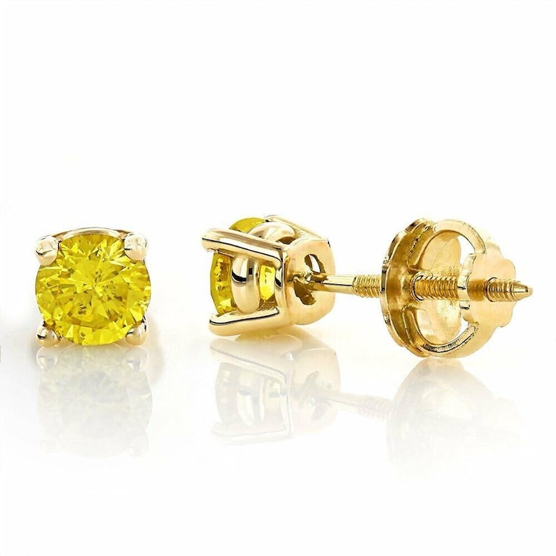 K&ouml;nnte beinhalten: Ein Paar gelbe Edelstein-Ohrstecker mit Goldfassung. Die Ohrringe haben einen runden, leuchtend gelben Edelstein. Die Goldfassung hat ein Vier-Zacken-Design, und die Ohrringpfosten haben einen Schraubverschluss.