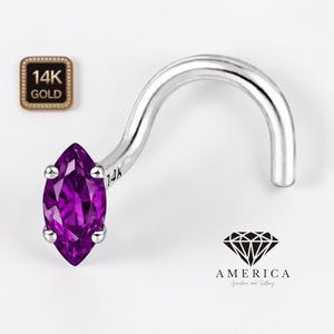 May include: A silver nose ring with a marquise-cut, deep purple gemstone. The ring is curved and features a 14K gold stamp. The gemstone is held in place by four small prongs. The image also includes a logo with the word "AMERICA".