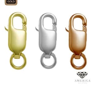 May include: Three metal lobster clasps in gold, silver, and rose gold. Each clasp has a spring-loaded lever and a small ring at the base. The upper left corner has a 14K gold stamp.