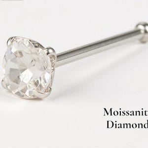 May include: A silver nose stud with a large, clear, round-cut moissanite diamond. The moissanite is set in a four-prong setting. The text "Moissanite Diamond" is below the stud.