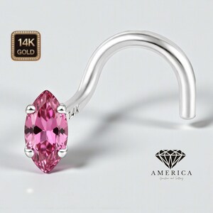 May include: A 14K gold nose ring with a marquise-cut pink gemstone. The curved, silver-colored metal is stamped with "14K". The image also includes a logo with the word "AMERICA" and the words "Jewelry and Setting".