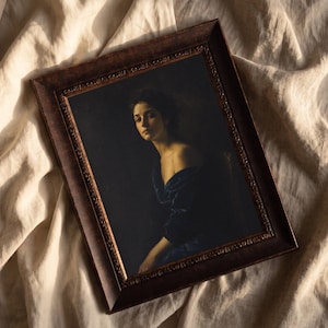 Può includere: Una cornice rettangolare in legno decorato marrone scuro contenente un ritratto di una persona dai capelli scuri che indossa un indumento blu scuro con spalle scoperte. Il dipinto presenta un'illuminazione ad alto contrasto.