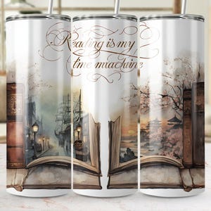 May include: A white stainless steel tumbler with a wraparound watercolor design. The design features an open book with a cityscape and a ship, and the text "Reading is my time machine". The tumbler has a silver straw.