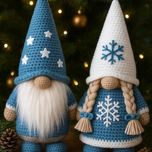 May include: Two handmade crochet gnomes, one male and one female, in winter attire. The male gnome wears a blue hat with white stars and has a long white beard. The female gnome has a white hat with a snowflake and braided hair. Both have blue outfits.