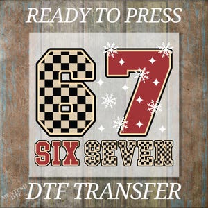 May include: A DTF transfer design featuring the number "67" with a checkered pattern on the "6" and a red background on the "7". The words "SIX SEVEN" are below the numbers, and the text "READY TO PRESS" and "DTF TRANSFER" are above and below the design.