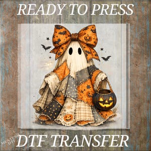 May include: A DTF transfer featuring a ghost wearing a large orange and black patterned bow and a patchwork cloak with various Halloween prints. The ghost holds a black jack-o'-lantern bucket. The text READY TO PRESS DTF TRANSFER is visible.