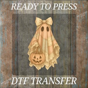May include: A vintage-style DTF transfer featuring a ghost in a sheet with a bow and holding a jack-o'-lantern. The ghost has oval eye holes and is in a peach color with lace trim. The words "READY TO PRESS" and "DTF TRANSFER" are at the top and bottom.