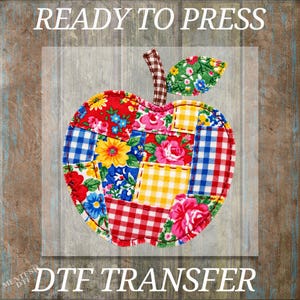 May include: A DTF transfer featuring an apple shape composed of various patchwork fabric patterns including red, blue, and yellow floral prints, gingham checks, and a brown checkered stem. The text READY TO PRESS DTF TRANSFER is visible.