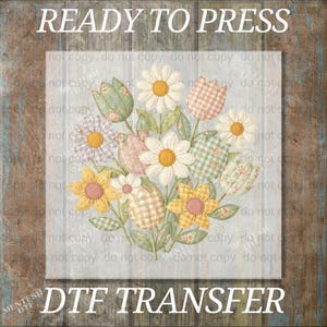 May include: A floral DTF transfer design featuring a bouquet of daisies, tulips, and other flowers in pastel colors. The flowers have a quilted appearance with gingham and floral patterns. The words "READY TO PRESS" and "DTF TRANSFER" are printed on the image.