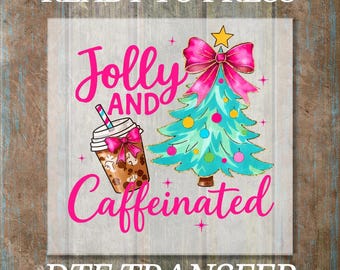 Könnte beinhalten: Ein DTF-Transferdesign mit den Worten "READY TO PRESS" oben und "DTF TRANSFER" unten. Das Design zeigt einen Weihnachtsbaum, ein Kaffeegetränk und die Worte "Jolly and Caffeinated" in Pink.
