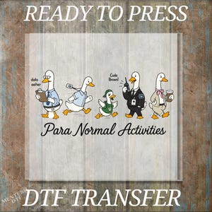 May include: A DTF transfer sheet featuring five cartoon ducks in various outfits with the text "READY TO PRESS", "data aether", "Code Brown!", "Para Normal Activities", and "DTF TRANSFER". The ducks wear office attire, a green vest, a suit, and a bowtie.