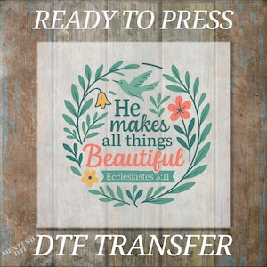 May include: A DTF transfer with the text "READY TO PRESS" at the top and "DTF TRANSFER" at the bottom. The design features a floral wreath with a bird and the words "He makes all things Beautiful" and "Ecclesiastes 3:11".