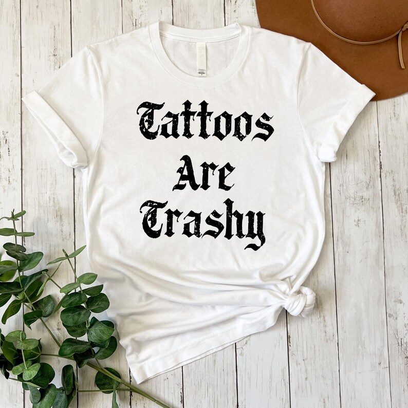 a white shirt that says tattoos are trashy