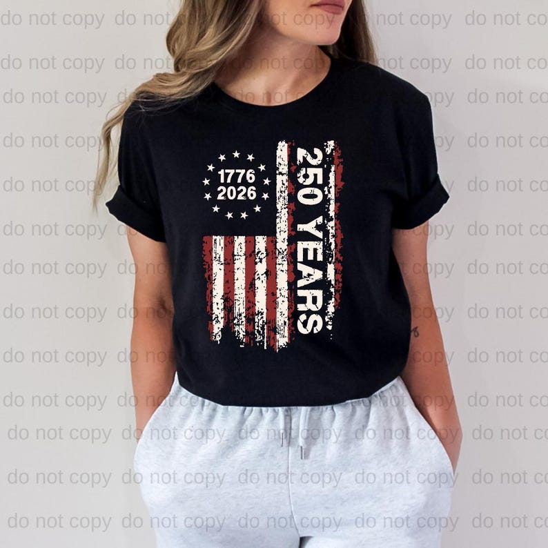 A woman wearing a black t-shirt with a graphic design featuring the text "1776 2026 250 YEARS" and an American flag pattern.