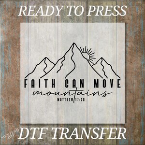 May include: A DTF transfer with the text "READY TO PRESS" at the top and "DTF TRANSFER" at the bottom. The design features a mountain range with a rising sun and the words "FAITH CAN MOVE mountains" and "MATTHEW 17:20".