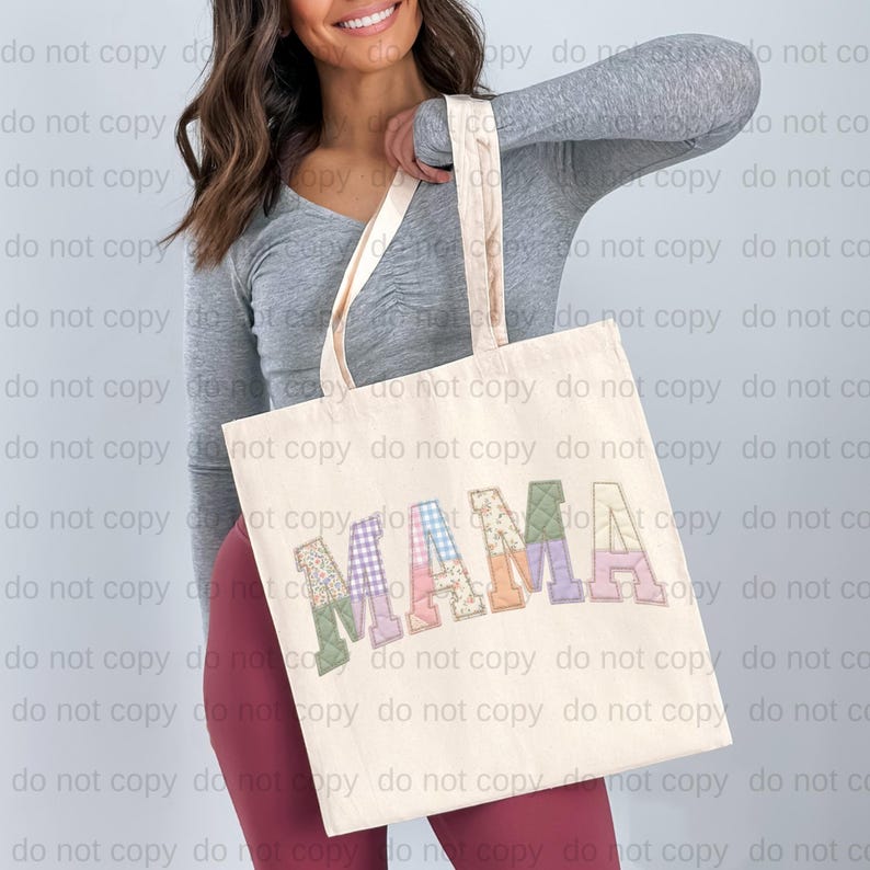 A woman is holding a large tote bag with the word "MAMA" printed on it.