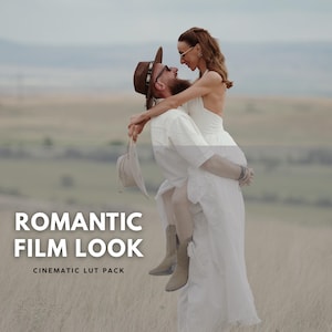 May include: A couple embraces outdoors, the man carrying the woman. The man wears a brown hat and sunglasses, and the woman wears a white dress. The text "ROMANTIC FILM LOOK" and "CINEMATIC LUT PACK" are displayed.