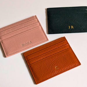 Orange, blush and black cardholder wallets.
