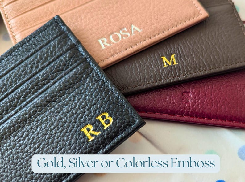 Hand holding a pink, blush and burgundy cardholder wallet.