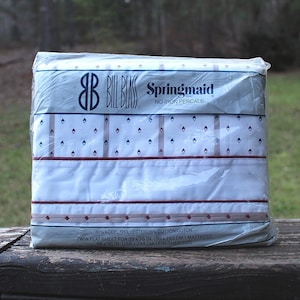 May include: A white twin flat sheet in a plastic package. The package has a blue and white label with the text "Springmaid No Iron Percale" and the Bill Blass logo. The sheet is 80% polyester and 20% cotton.