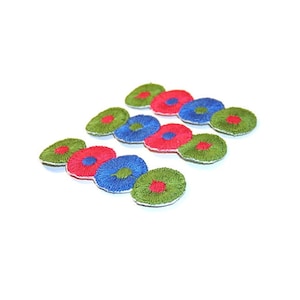 May include: Three rows of embroidered fabric circles in green, red, and blue. The circles are arranged in a pattern of alternating colors.