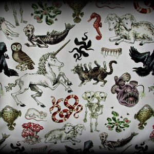 May include: A white fabric featuring a repeating pattern of illustrations including a white unicorn, a two-headed lamb, a multi-legged cat, a skeleton with two skulls, a mermaid skeleton, black ravens, anglerfish, snakes, and Venus flytraps.