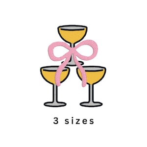 May include: An embroidered design of three champagne glasses filled with yellow liquid, arranged in a pyramid. A pink bow is tied around the glasses. The text "3 sizes" is below the glasses.