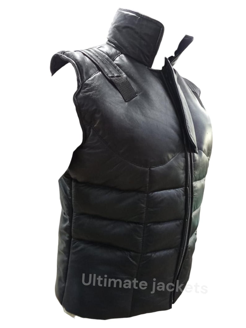 May include: Black leather vest with a high collar and a full-length zip. The vest has a quilted design and shoulder straps. The text "Ultimate jackets" is printed at the bottom of the vest.
