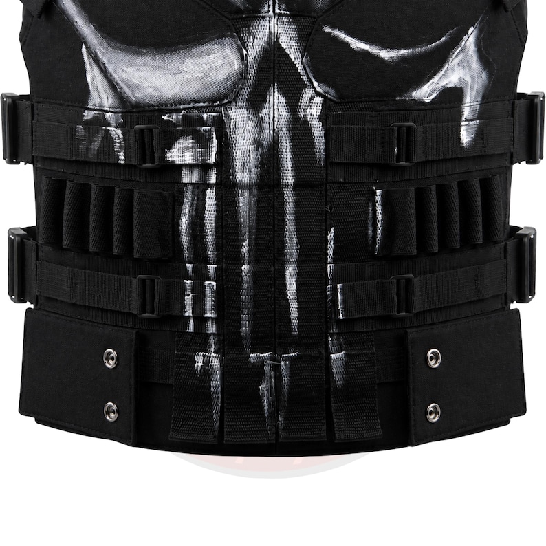May include: Black tactical vest with multiple pouches and adjustable straps. The vest features a white skull design on the chest area. The vest has multiple rows of loops and pouches for carrying equipment. The vest is made of durable, heavy-duty material.