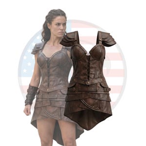 May include: Brown leather armor set featuring a corset-style top with lace-up detailing and a layered skirt. The set includes shoulder pauldrons and arm guards. The design evokes a warrior or fantasy theme, with a focus on protection and style.