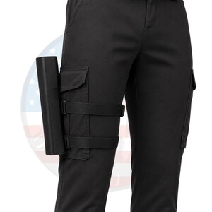 May include: Black cargo pants with a holster attached to the left leg. The holster is black and secured with adjustable straps. The pants have cargo pockets and a classic design.